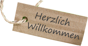 Das Bild zeigt einen braun-beigen Geschenkanhänger mit Kordel, der die zweizeilige Aufschrift Herzlich Willkommen trägt.